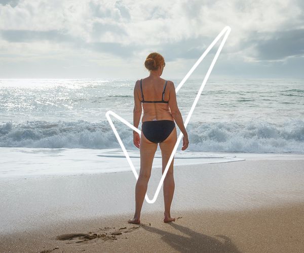 woman at the beach staring out at the water